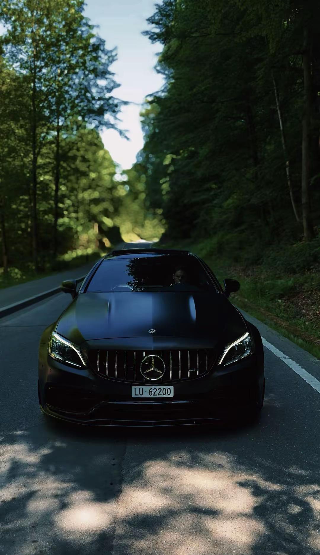 Unser Mercedes-AMG C63 S Coupé auf einer von Wald gesäumten Strasse